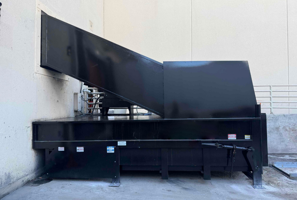 Komar compactor connected to chute